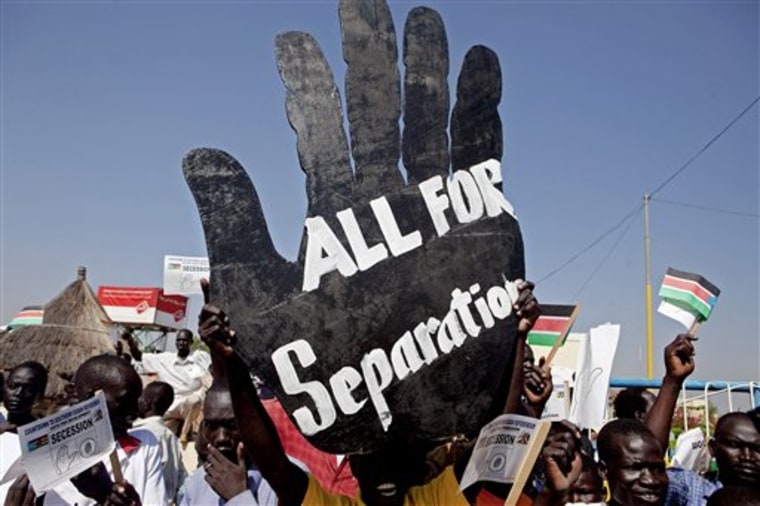 FILE-- In this Tuesday Jan.4 2011 file photo, Pro-separation activists hold signs and chant pro-independence slogans outside the Juba airport in southern Sudan where Sudanese President Omar al-Bashir arrived. Separation or unity. A solitary hand or two of them clasped together. That's the choice _ and the ballot image _ that close to 4 million registered voters in Southern Sudan will face beginning Sunday, when a seven-day referendum on separation from the Khartoum-based north begins. The vote, which is likely to lead to the world's newest country, is the culmination of a 2005 peace deal that ended 20-plus years of north-south civil war. (AP Photo/Pete Muller/file)